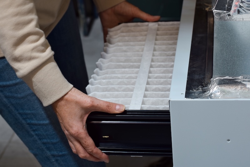 Woman is replacing furnace filter at home